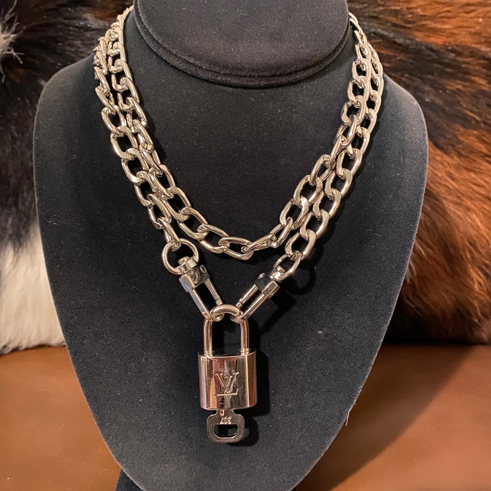 Louis Vuitton Silver finished lock and key. The chain is 16” before the 2” lock